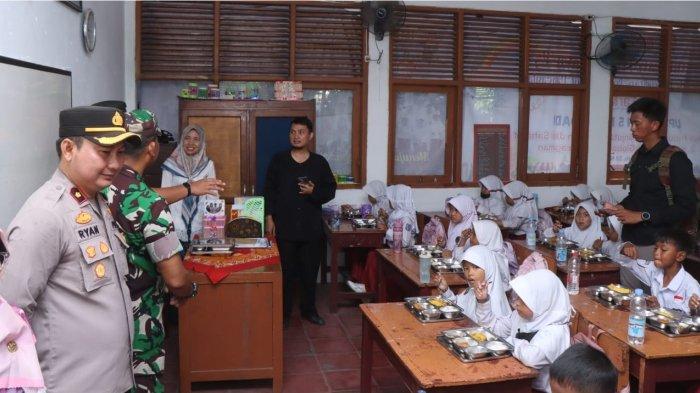 Caption: Polisi saat ikut memantau program makan bergizi gratis di Indramayu, Selasa (7/1/2025)