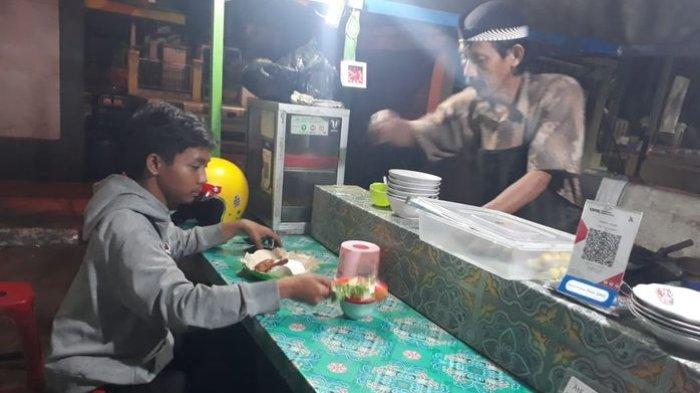 Abdul Mukhid (52), pemilik UMKM Soto dan Pecel Lele Lamongan Warna Alam sedang melayani pembeli.