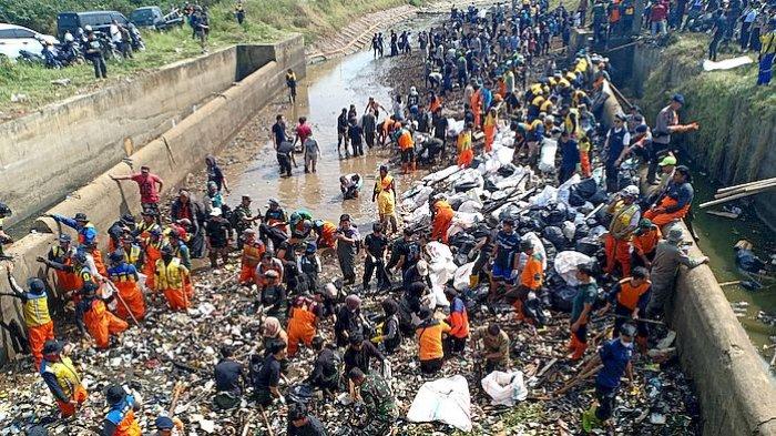 Ratusan orang turun ke Bendungan Cibugel, Sungai Cikeruh, Desa Cimekar, Kecamatan Cileunyi, Kabupaten Bandung, untuk membersihkan sampah, Rabu (26/7/2023)