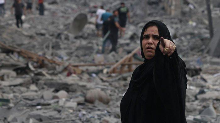 Seorang perempuan warga Gaza berjalan di tengah reruntuhan bangunan akibat serangan udara Israel di wilayah al-Rimal, Gaza City, Selasa (10/10/2023). Israel melancarkan pengeboman besar-besaran pada Gaza sebagai balasan atas serangan militan Hamas pada Sabtu (7/10/2023). Kekerasan militer antara Hamas dan Israel telah menewaskan lebih dari 1.000 orang.
