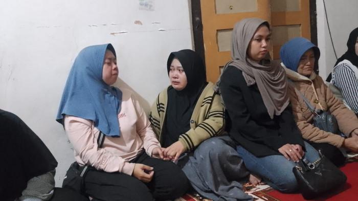 SUASANA DUKA - Mela Puri Anggani (31) (kerudung biru sebelah kiri) ketika ditenangkan oleh saudaranya di kediamannya di Kampung Sindanghela, RT 02/03, Kelurahan Sukamentri, Kecamatan Garut Kota, Kabupaten Garut, Jumat (18/7/2025).