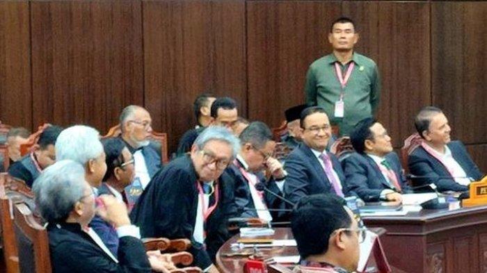 Momen Anies Baswedan menoleh ke arah Ganjar Pranowo sambil tersenyum saat hakim menolak dalil-dalil mereka soal keberpihakan penjabat kepala daerah dan ASN dalam masa kampanye Pilpres 2024 dalam sidang pembacaan putusan sengketa Pilpres 2024 di Mahkamah Konstitusi, Senin (22/4/2024).
