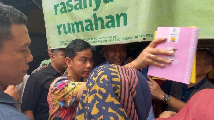 Calon wakil presiden no 2, Gibran Rakabuming Raka membagikan buku tulis ke siswa-siswi SMK 1 Pasundan Kota Bandung, Selasa (30/1/2024).