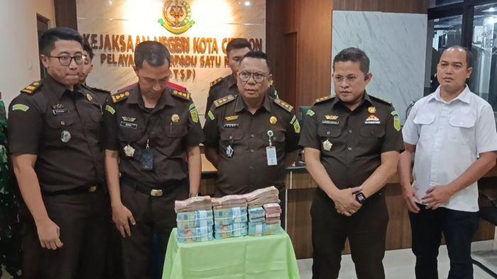 UANG KORUPSI - Pihak Kejaksaan Negeri (Kejari) Kota Cirebon menunjukkan uang hasil korupsi dana PIP SMAN 7 Cirebon dalam konferensi pers yang berlangsung Selasa (22/7/2025) malam.Kejari Kota Cirebon sudah menetapkan empat tersangka.