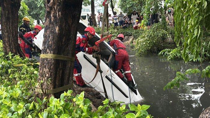 Proses evakuasi mobil tercebur ke sungai usai tabrakan beruntun di Surabaya, Senin (23/12/2024).