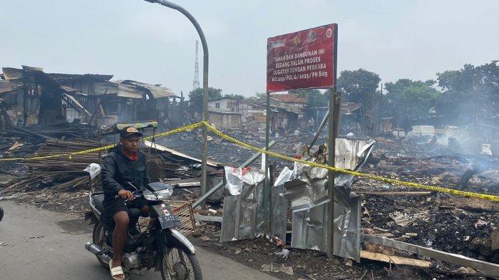 SISA KEBAKARAN - Seorang pengendara motor saat melintas di lokasi kebakaran Jalan Terusan Pasir Koja, Gang Satata Sariksa, RT 08/04, Kelurahan Sukahaji, Kecamatan Babakan Ciparay, Kota Bandung, Kamis (10/4/2025)