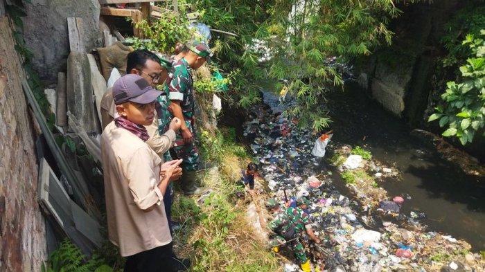 Sejumlah warga dan anggota TNI membersihkan sampah yang dibuang oleh dua oknum warga di Sungai Citopeng Kelurahan Cibeureum, Kecamatan Cimahi Selatan, Kota Cimahi, Kamis (7/9/2023).