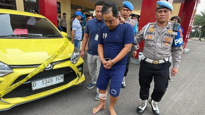 Ujang alias Kampeng (39), pelaku pengeroyokan polisi yang videonya viral, digiring aparat di Mapolresta Bandung, Minggu (24/12/2023).