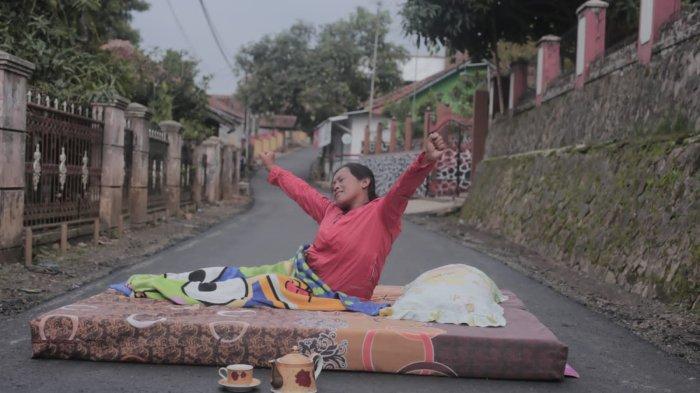 Warga menggelar kasur di atas aspal di ruas jalan Rancakalong-Sabagi di Desa Rancakalong dan Desa Pamekaran, Kecamatan Rancakalong, Sumedang, Rabu (13/12/2023).