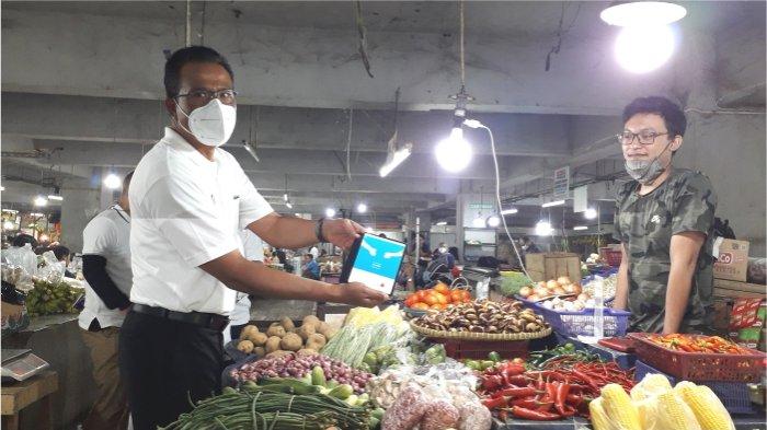 Regional CEO BRI Bandung Ida Bagus Ketut Subagia melakukan transaksi dengan QRIS BRI kepada salah satu pedagang sayuran di pasar Kosambi
