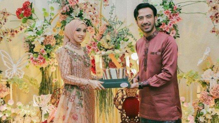 Foto lamaran Reza DA dan Amira Karaman berfoto bersama sembari memegang sebuah hantaran