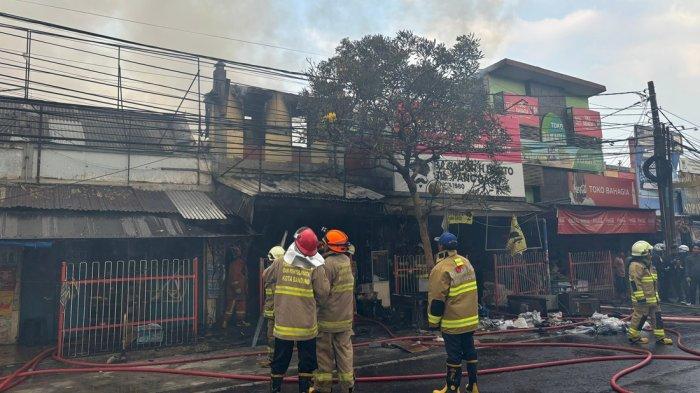 Petugas melakukan pendinginan di Pasar Simpang Dago, Kota Bandung yang terbakar, Jumat (26/7/2024) sekitar pukul 15.26 WIB.