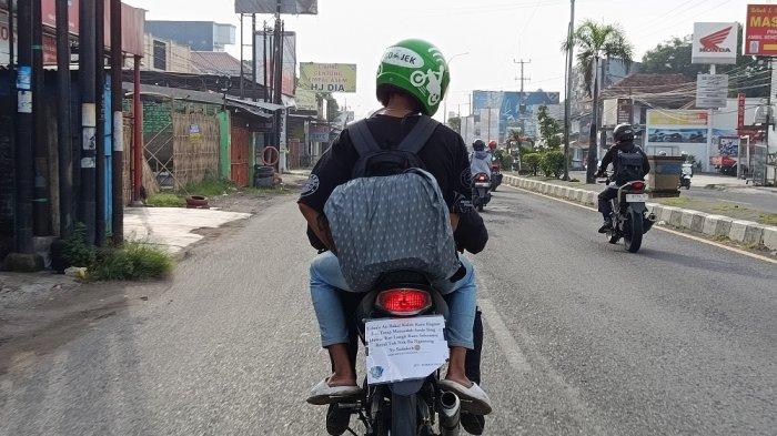PEMUDIK UNIK - Di Jalur Pantura Cirebon, Selasa (25/3/2025), berbagai tulisan nyeleneh yang ditempel di bagian belakang motor pemudik berhasil mencuri perhatian.
