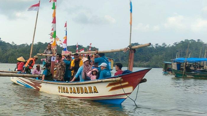 Perahu nelayan berhiaskan bendera dan pernak-pernik pawai di aliran Sungai Citanduy, Kalipucang, Senin (23/10/2023). Kegiatan ini menyambut milangkala ke-11 Kabupaten Pangandaran.
