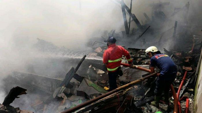 Petugas Damkar Sumedang saat memadamkan api di rumah kontrakan yang terbakar.