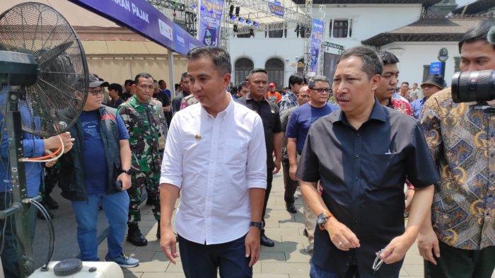 Pj Gubernur Jawa Barat Bey Machmudin didampingi Kepala Bapenda Jabar Dedi Taufik saat mengunjungi booth Bapenda Jabar pada acara pembukaan Road to Giias Bandung di halaman Gedung Sate Bandung, Sabtu (18/11/2023).