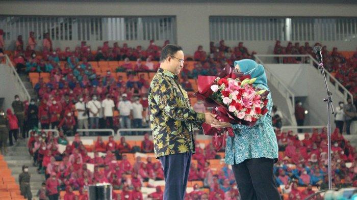 Gubernur DKI Jakarta Anies Baswedan memberikan bunga kepada istrinya, Fery Farhati di depan puluhan ribu kader PKK di JIS, Jakarta Utara, Sabtu (16/7/2022).