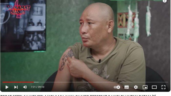Heru Gundul saat memperlihatkan tato bunga terong di bahu kanannya.