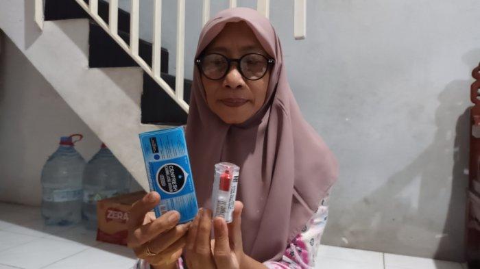 Ibunda Abidzar, Rubiati (52) saat menunjukkan obat tetes mata yang digunakan anaknya untuk proses pemulihan dampak penyiraman air keras, Jakarta Timur, Jumat (11/8/2023).