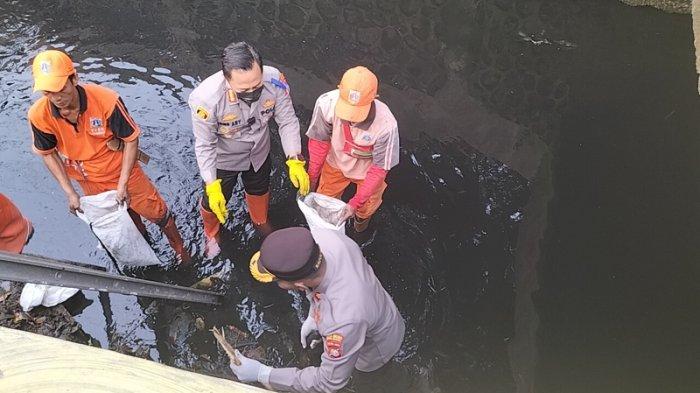 Kapolres Metro Jakarta Selatan Kombes Ade Ary Syam Indradi saat membersihkan Kali Uangan di Pesanggrahan, Jakarta Selatan yang hitam pekat dipenuhi sampah, Kamis (13/7/2023).
