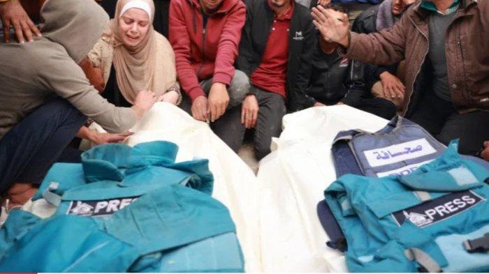 Kerabat dan kolega jurnalis Palestina Hassouneh Salim dan Sari Mansour, yang tewas dalam serangan udara Israel, berduka atas jenazah mereka saat pemakaman mereka di Deir al-Balah di Jalur Gaza selatan pada 19 November.