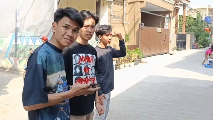 GEBRAKAN KETUA RT GEN Z - Sahdan Arya Maulana (kiri) menunjukkan jalan rusak di RT 07 RW 08 Rawa Badak Selatan, Koja, Jakarta Utara, yang telah diperbaiki. Arya yang berusia 19 tahun menjadi ketua RT dari kalangan Gen Z yang bergerak cepat menangani kebutuhan warga bersama pemuda setempat. (TRIBUNJAKARTA.COM/GERALDĀ LEONARDO AGUSTINO).