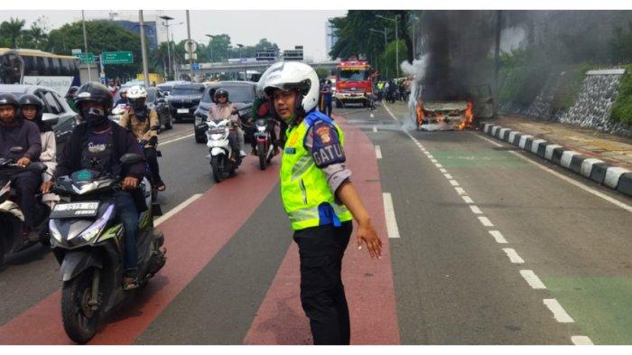 Mobil terbakar di Jl Gatot Subroto arah Slipi, Minggu (7/1/2024).