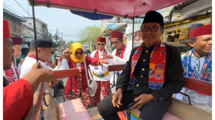 PURNA TUGAS LURAH RUSMIN - Lurah Kalibaru Rusmin dan sang istri diarak keliling wilayah Kelurahan Kalibaru, Cilincing, Jakarta Utara, dalam momen pelepasan setelah masa purna tugas. Rusmin diketahui telah 27 tahun mengabdi sebagai ASN Pemprov DKI Jakarta sebelum purna bakti per 1 Juni 2025. (TRIBUNJAKARTA.COM/GERALD LEONARDO AGUSTINO).