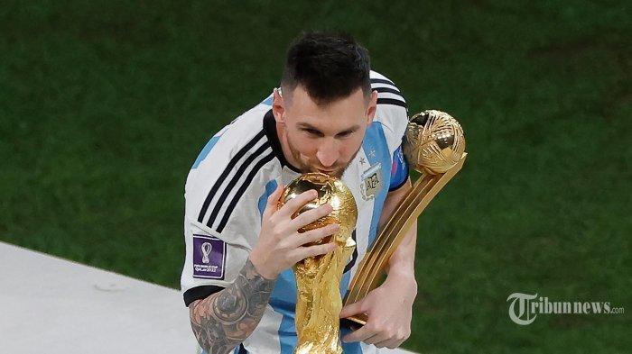 Pemain depan Argentina Lionel Messi mencium trofi Piala Dunia setelah menerima penghargaan Bola Emas pada upacara trofi Piala Dunia Qatar 2022 setelah pertandingan final sepak bola antara Argentina dan Prancis di Stadion Lusail di Lusail, utara Doha. (18 Desember 2022).
