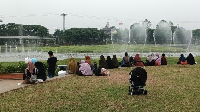 Pengunjung TMII saat menikmati pertunjukan Tirta Menari atau air mancur menari dan permainan tradisional anak di area Hompimpark, Cipayung, Jakarta Timur