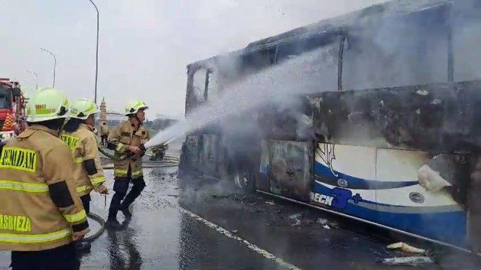 Personel Damkar Jakarta Timur saat melakukan proses pemadaman pada bus yang terbakar di Tol Wiyoto Wiyono, Jatinegara, Kamis (24/10/2024).