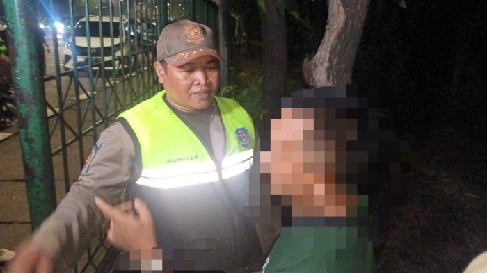 Personel Satpol PP Jakarta Timur saat mengamankan pria diduga penyuka sesama jenis di Hutan Kota Cawang, Makasar, Selasa (25/7/2023).