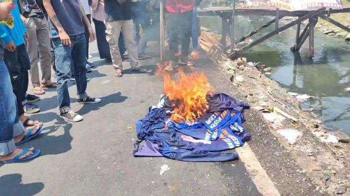 Abdul Rosyid Arsyad dan simpatisan Partai NasDem dari pedagang Pasar Kalimalang Cakung mencopot dan membakar atribut Partai NasDem, Cakung, Jakarta Timur, Senin (4/9/2023).