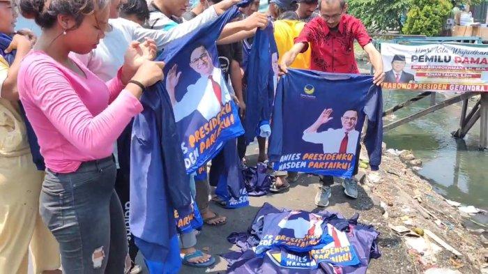 Simpatisan Partai NasDem dari pedagang Pasar Kalimalang Cakung mencopot dan membakar atribut Partai NasDem di Cakung, Jakarta Timur, Senin (4/9/2023).