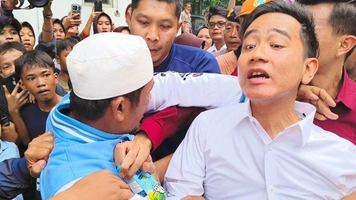 Warga Rusun Muara Baru mencoba memeluk Gibran lalu diamankan ajudan saat kunjungan ke Rusun Muara Baru, Penjaringan, Jakarta Utara, Rabu (24/4/2024).