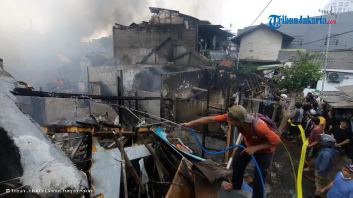 Warga membantu proses pemadaman kebakaran di Jalan Juraganan, Grogol Utara, Kebayoran Lama, Jakarta Selatan, Minggu (20/7/2025). (TribunJakarta.com/Annas Furqon Hakim).