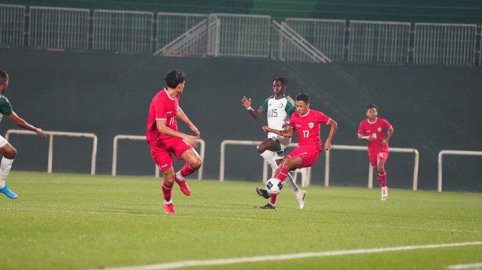 Bek sayap Timnas Indonesia U-23 Dony Tri Pamungkas berusaha melindungi bola dari rebutan pemain Arab Saudi.