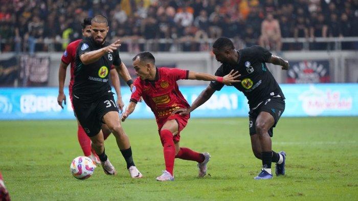Winger Persija Jakarta, Riko Simanjuntak diapit dua pemain Barito Putera Levy Madinda di Liga 1.