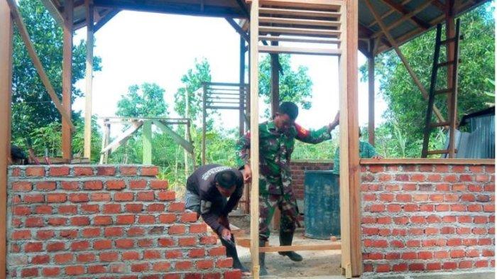 Satgas TNI Manunggal Membangun Desa (TMMD) ke 122 Kodim 0420 Sarko membantu pemasangan kusen pintu dan jendela rumah milik warga Desa Bedeng Rejo