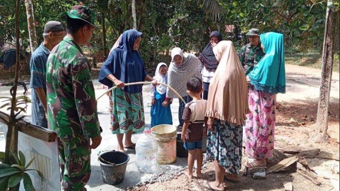 Warga Desa Sukamaju, Kecamatan Mestong, Kabupaten Muaro Jambi, yang tengah mengambil air di sebuah sumur bor di tengah desa.