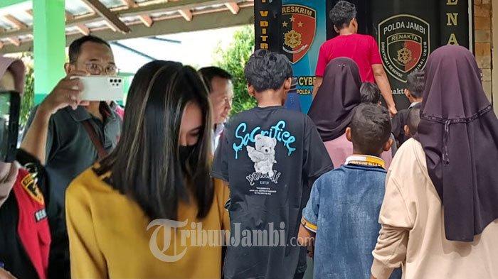 Polisi saat membawa YSA alias NT ke Rumah Sakit Jiwa (kiri) dan saat anak-anak melaporkan NT ke Polda Jambi (kanan)