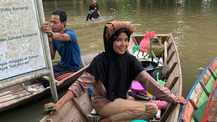 PASAR TERAPUNG - Ibu-ibu berjualan di atas sampan di halaman Candi Astano, Kabupaten Muarojambi, yang terendam banjir luapan Sungai Batanghari, Rabu (17/1).