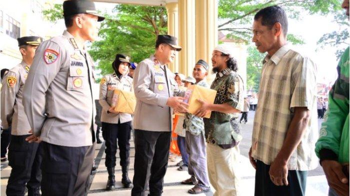 BANTUAN - Wakapolda Jambi, Brigjen Pol. M. Mustaqim, didampingi oleh Irwasda Polda Jambi Kombes Pol M. Jannus P. Siregar, serta para Pejabat Utama lainnya, serahkan bantuan sembako kepada masyarakat di Lobi Mapolda Jambi.