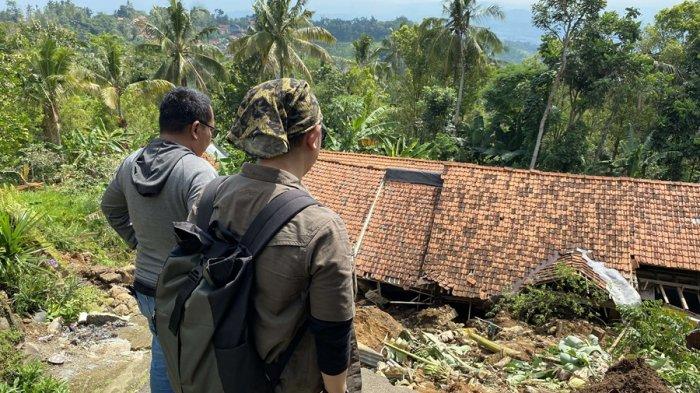 TANAH AMBLAS - Dua orang berdiri di tepian patahan tanah di Dukuh Krajan, Desa Mandala, Kecamatan Sirampog, Kabupaten Brebes, Rabu (27/5/2025). Akibat bencana geologi landslide, tanah di wilayah tersebut amblas hingga 15 meter.