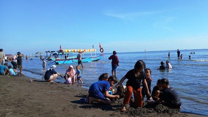LIBURAN - Pengunjung anak-anak sedang bermain pasir dan air laut di Pantai Alam Indah (PAI) Tegal, Minggu (8/6/2025). Berdasarkan catatan Disporapar Kota Tegal, ada sekira 10 ribu pengunjung memadati wisata tersebut selama tiga hari libur Iduladha tahun ini.