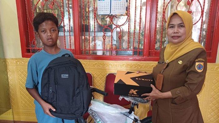 BERI PERLENGKAPAN SEKOLAH: Kepala Dindikpora Brebes, Carida (kanan), menyerahkan perlengkapan sekolah berupa sepeda, sepatu, dan tas dari Bupati Brebes kepada Adnan. (DOK. DINDIKPORA BREBES)