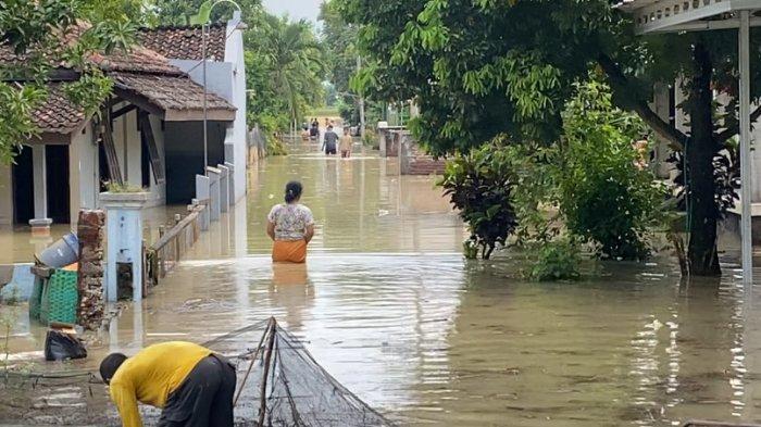 TEMBUS GENANGAN - Warga menembus genangan air setinggi perut saat banjir yang melanda Dusun Kedungwundu, Desa Tanggirejo, Kecamatan Tegowanu, Kabupaten Grobogan pada Rabu (18/6/2025). Sejumlah barang termasuk motor juga terendam.