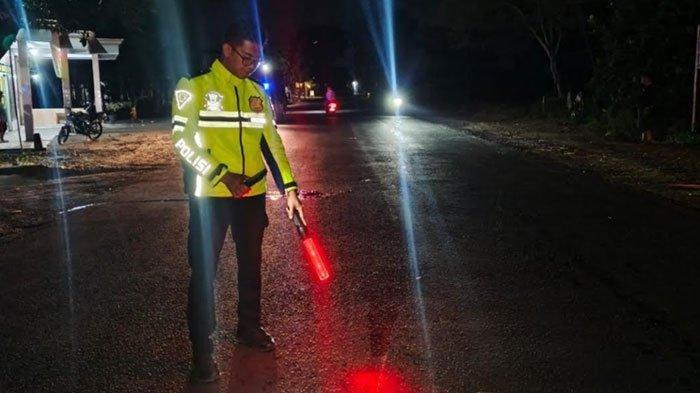 LOKASI KECELAKAAN - Anggota Satlantas Polres Tulungagung menunjukkan lokasi kecelakaan di Desa Wajak Lor, Kecamatan Boyolangu, Kabupaten Tulungagung, Jawa Timur, pada Minggu (6/7/2025) malam. Pada kejadian ini seorang remaja laki-laki, SM (15), meninggal dunia sementara truk pikap yang menabraknya kabur. (TRIBUN JATIM/ISTIMEWA)