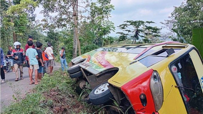 BUS TERGULING - Warga menyaksikan kondisi bus terguling di jalur alternatif Pati-Kudus arah Muria, tepatnya di Desa Japan, Kecamatan Dawe, Kabupaten Kudus, Selasa (8/7/2025). Bus ini membawa rombongan wisata dari Tayu, Kabupaten Pati hendak menuju destinasi wisata Pijar Park di Desa Kajar, Kecamatan Dawe, Kudus.