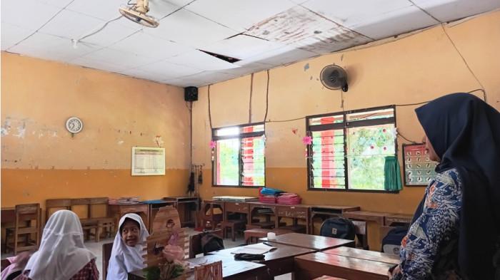 ATAP RUSAK - Beberapa siswa belajar di ruang kelas 2 SD Negeri 5 Ngembalrejo Kudus yang atapnya ambrol, Kamis (17/7/2025). Kerusakan atap terebut sudah berlangsung lebih dari setahun dan belum mendapatkan perhatian dari Pemkab Kudus.